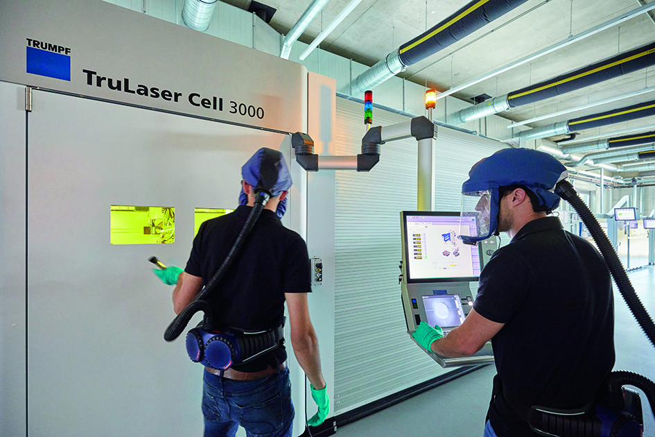 Teamwork with science-fiction flair: Florian Schlund and Jonathan Krauß from toolcraft use respirators to protect themselves from tiny metal particles in 3D printing processes like EHLA. 