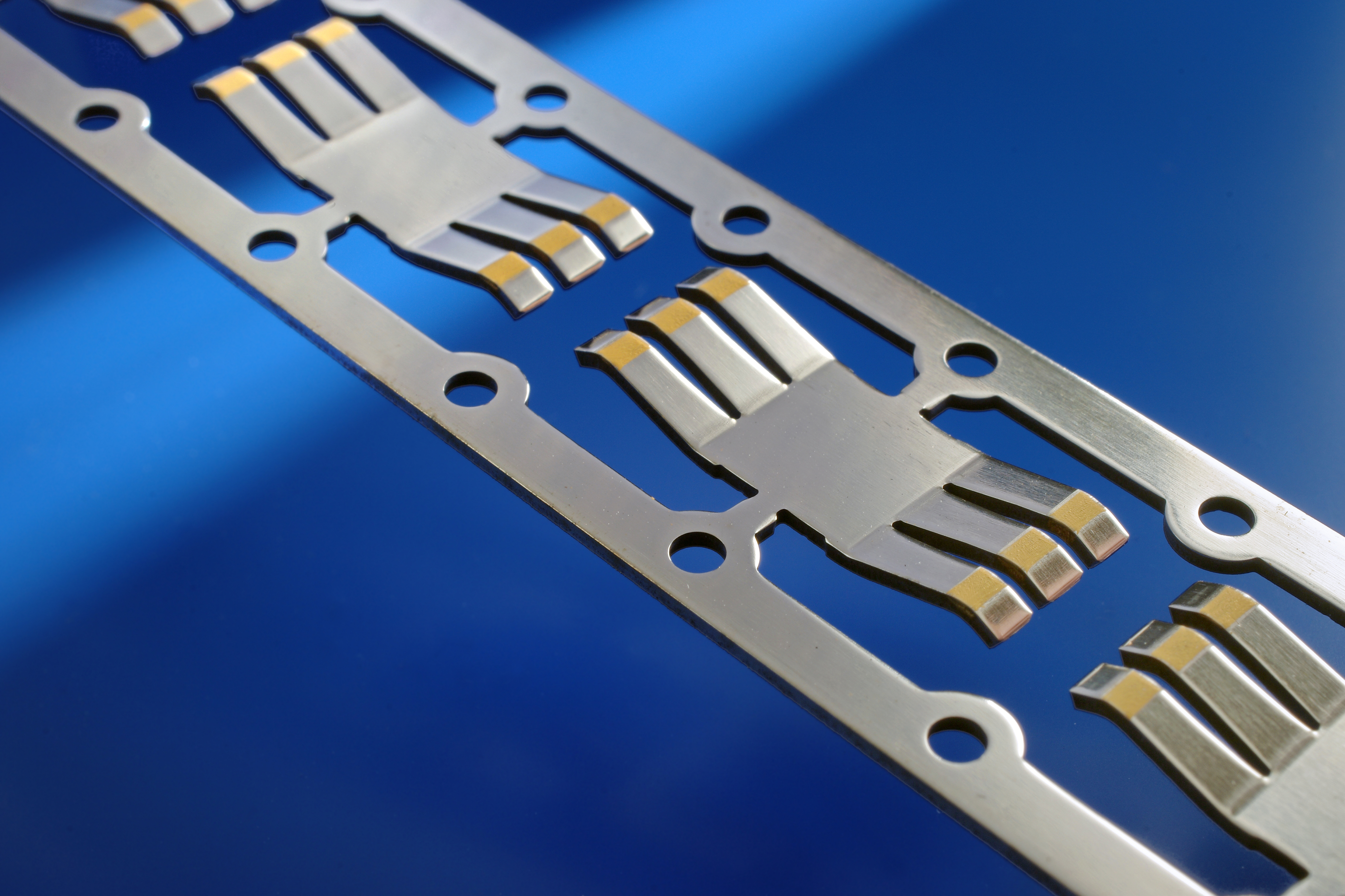 Selective gold contacts on a metal component made with printing and laser processes.